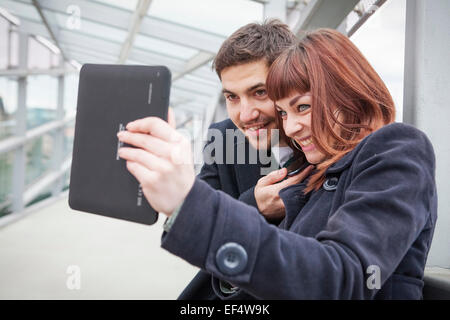 Coppia giovane in edificio aeroportuale prendendo un ritratto di auto Foto Stock