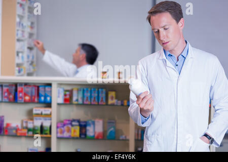 Concentrando il farmacista la lettura di etichetta sul vaso di medicina Foto Stock