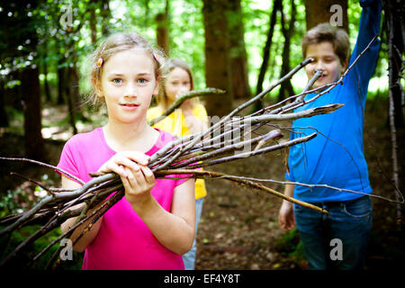 Bambini il prelievo di legna da ardere nella foresta, a Monaco di Baviera, Germania Foto Stock