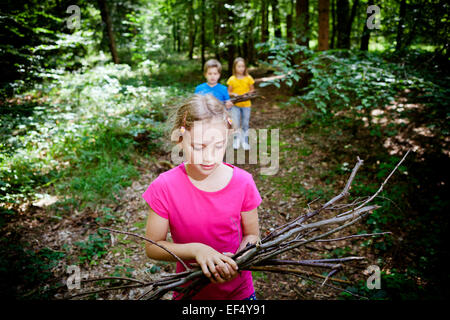 Bambini il prelievo di legna da ardere nella foresta, a Monaco di Baviera, Germania Foto Stock