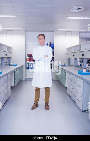 Sorridente biochimico in piedi con le braccia incrociate Foto Stock