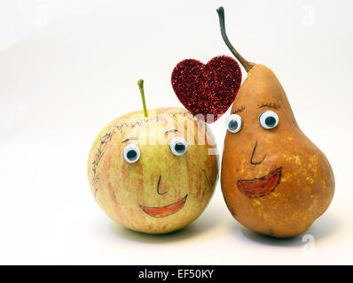 Divertimento giovane in amore frutta mela e pera e grande cuore rosso Foto Stock
