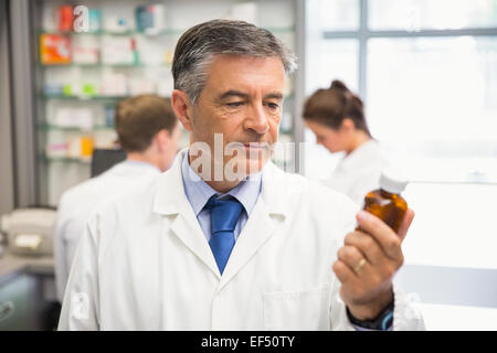 Senior farmacista cercando in medicina Foto Stock