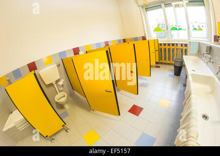 Piccolo bagno di una scuola per bambini con water e lavandino bianco Foto Stock