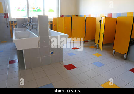 All'interno del bagno della scuola materna con dissipatori di bianco e giallo delle porte Foto Stock