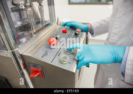 Il farmacista utilizzando macchinari di fare medicina Foto Stock