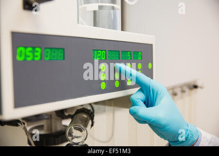 Il farmacista utilizzando macchinari di fare medicina Foto Stock