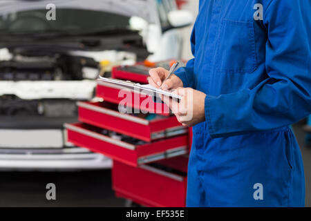 Mechanic la scrittura su una clipboard Foto Stock