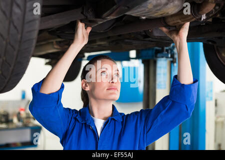 Mechanic esaminando sotto la vettura Foto Stock