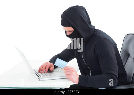 Hacker utilizzando laptop e carta di credito Foto Stock