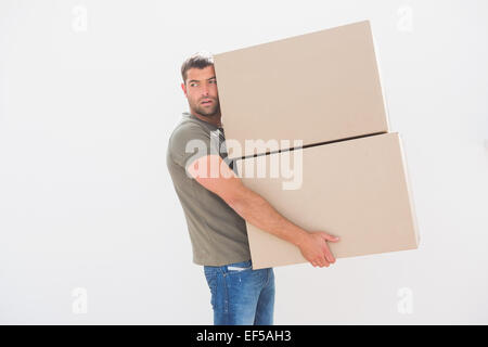 Uomo che porta in cartone scatole in movimento a casa Foto Stock