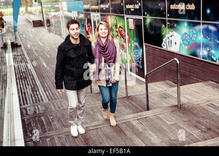 Felice coppia giovane holding hands in città Foto Stock
