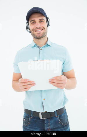 Corriere uomo che indossa la cuffia mentre si tiene negli appunti Foto Stock