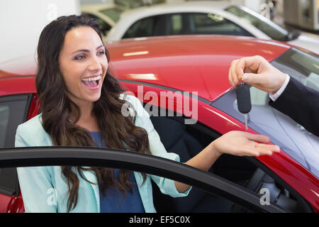 Excited donna riceve chiave auto Foto Stock
