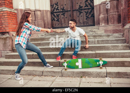 Coppia giovane con lo skateboard ingannare intorno a passi Foto Stock