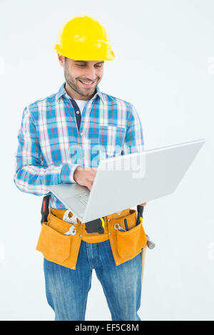 Felice lavoratore edile utilizzando laptop Foto Stock