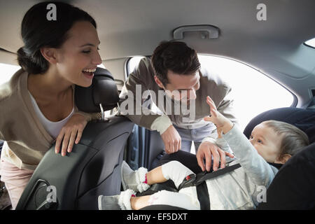 I genitori che fissano il bambino nel seggiolino per auto Foto Stock