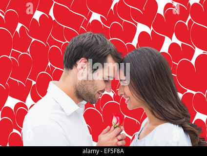 Immagine composita di uomo bello che offre la sua ragazza una rosa Foto Stock