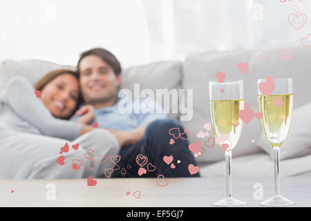 Immagine composita del giovane in appoggio su di un lettino con flauti di champagne Foto Stock