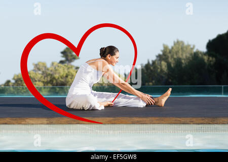 Immagine composita della pacifica brunette in janu sirsasana yoga pone a lato piscina Foto Stock