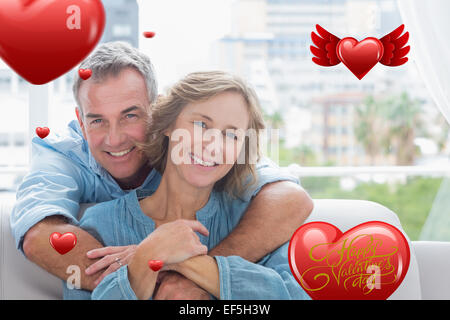 Immagine composita di contenuto uomo abbracciando la moglie sul lettino Foto Stock