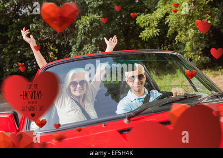 Immagine composita della coppia matura in rosso cabriolet tifo in telecamera Foto Stock