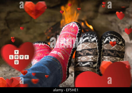 Immagine composita della chiusura del romantico gambe in calze davanti al camino Foto Stock