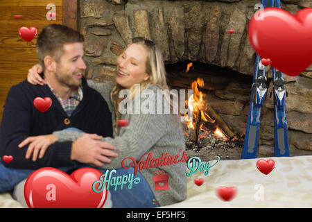Immagine composita di allegro giovane con le braccia intorno alla parte anteriore del caminetto acceso Foto Stock