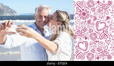 Immagine composita della coppia sposata in spiaggia insieme prendendo un selfie Foto Stock