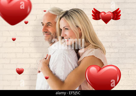 Immagine composita di affettuosa giovane in piedi e abbracciando Foto Stock