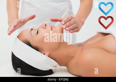 Immagine composita della pacifica brunette ricevendo la terapia reiki Foto Stock