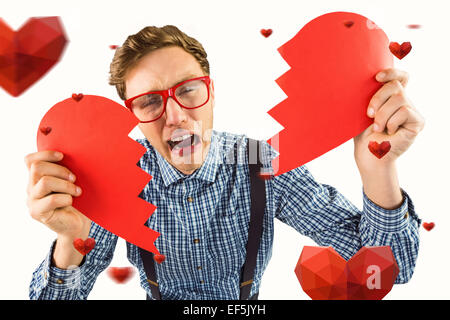 Immagine composita di geeky hipster tenendo un cuore spezzato Foto Stock