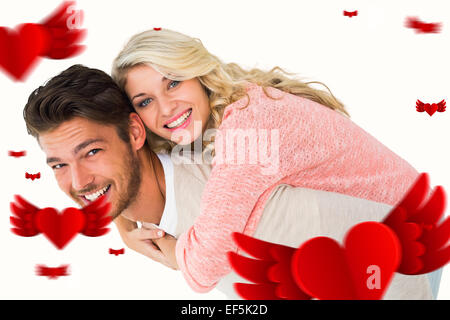Immagine composita di uomo bello dando piggy back alla sua ragazza Foto Stock