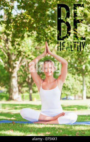 Immagine composita della cute giovane donna fare yoga seduto su un tappeto di esercizio Foto Stock