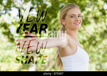 Immagine composita della giovane donna adatta a praticare lo yoga in un parco e diffondere le sue braccia Foto Stock