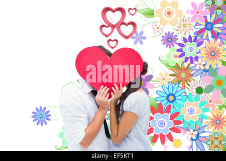 Immagine composita della giovane per la copertura del loro bacio con un cuore Foto Stock