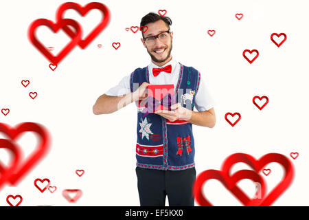 Immagine composita di geeky hipster offrendo regali di natale Foto Stock