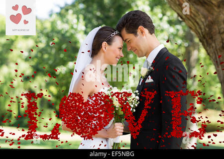 Immagine composita di amorevole coppia di novelli sposi in giardino Foto Stock
