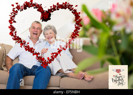 Immagine composita di felice coppia senior rilassante sul divano Foto Stock