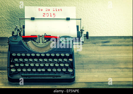 Nastri inchiostratori per macchine da scrivere con carta bianca pagina su un tavolo di legno. il testo di esempio per elenco impegni 2015. in stile vintage tonica foto Foto Stock