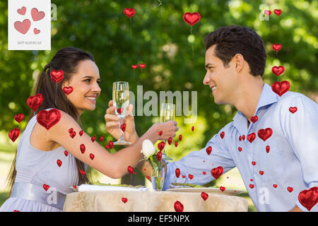 Immagine composita della giovane con champagne flauti seduta a outdoor cafÃ© Foto Stock