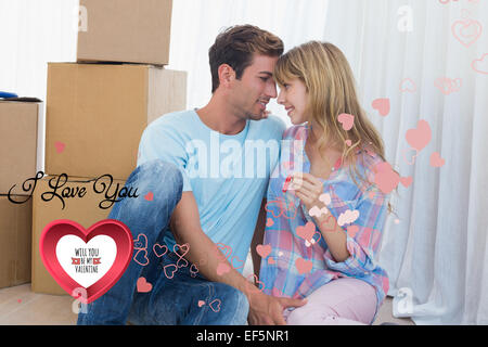 Immagine composita della giovane azienda casa nuova chiave contro le scatole di cartone Foto Stock