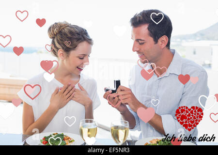 Immagine composita dell'uomo donna sorprendente con un anello di nozze al tavolo pranzo Foto Stock