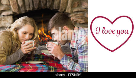 Immagine composita della coppia romantica bere il tè davanti al caminetto acceso Foto Stock