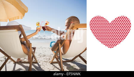 Immagine composita della coppia felice tintinnio loro bicchieri mentre vi rilassate sulle loro sedie a sdraio Foto Stock