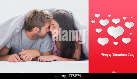 Immagine composita di allegro giovane testa contro testa sotto il piumino Foto Stock