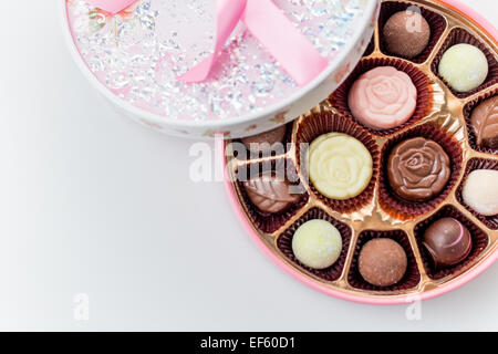 Rosa scatola di cioccolatini con nastro su sfondo bianco, girato da sopra Foto Stock