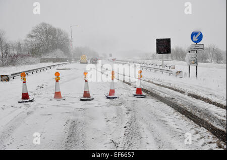 Coni di fronte strada chiusa da neve. A66, Cumbria, Regno Unito. Foto Stock