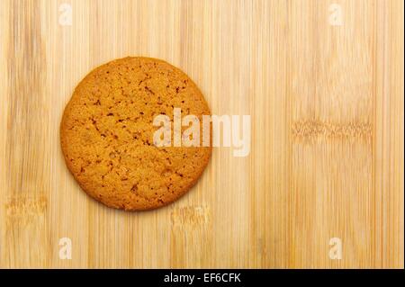 Un unico biscotto di zenzero su uno sfondo di legno Foto Stock