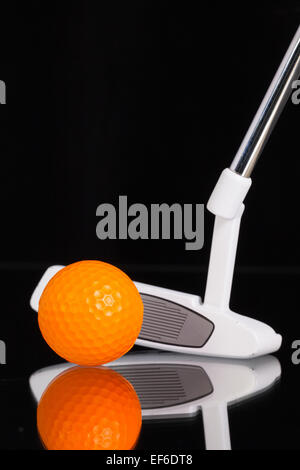 Golf putter e diverse attrezzature da golf sul vetro nero scrivania Foto Stock